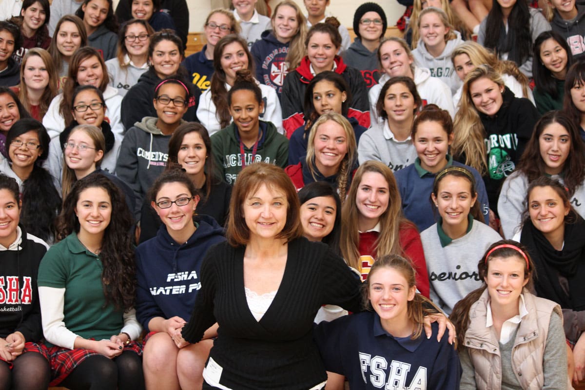 Group of smiling students and teacher together.